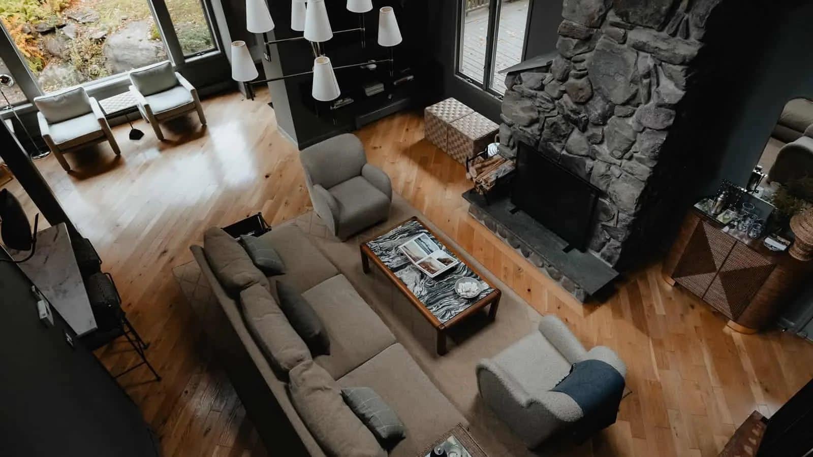 Great room with a stone fireplace and white oak floors, open to the level above