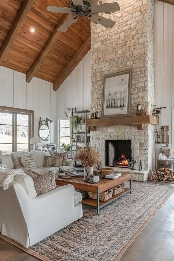 Stone fireplace running to the ceiling under a vaulted wood ceiling with shiplap walls