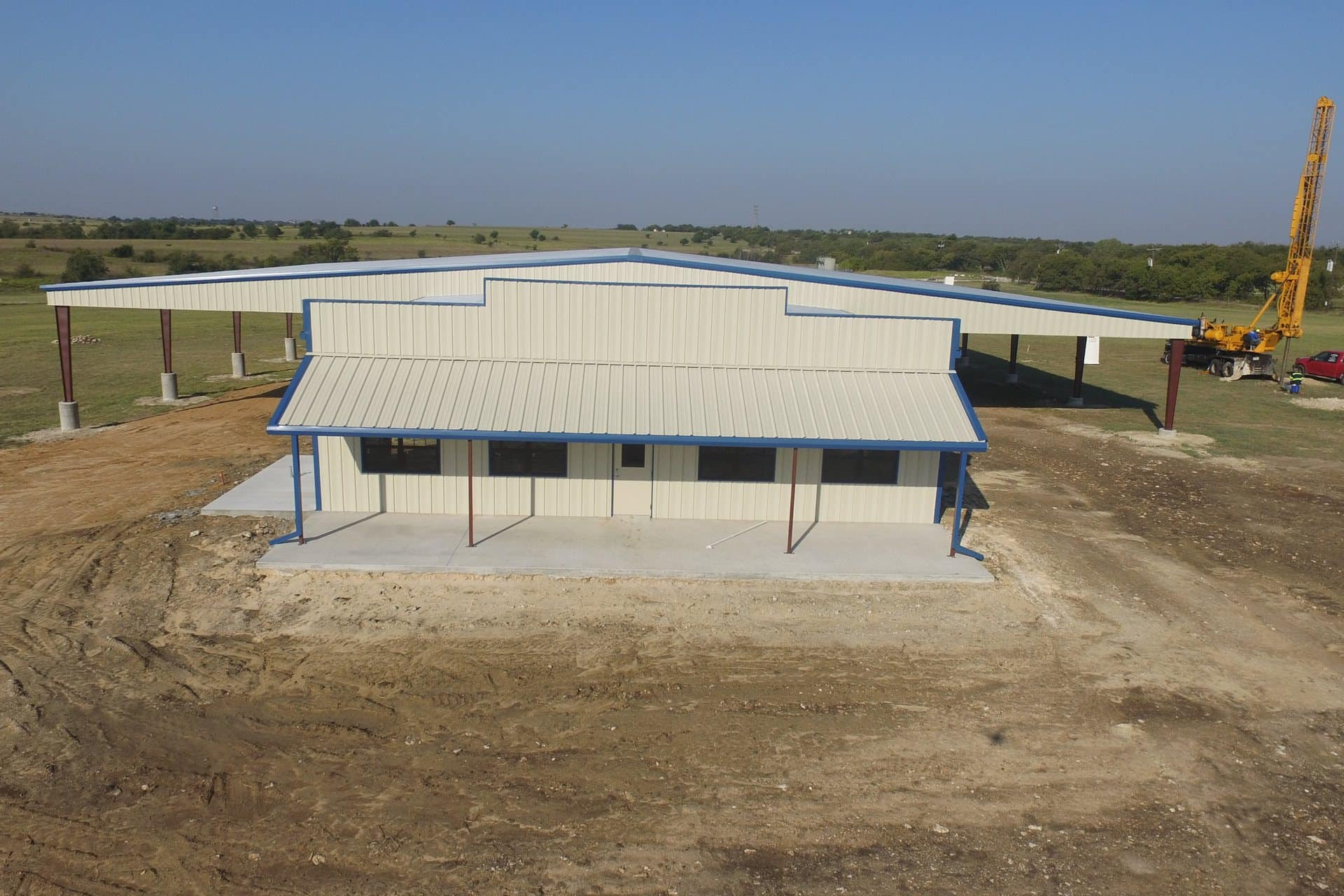 agricultural equipment building with wide covered lean to bays