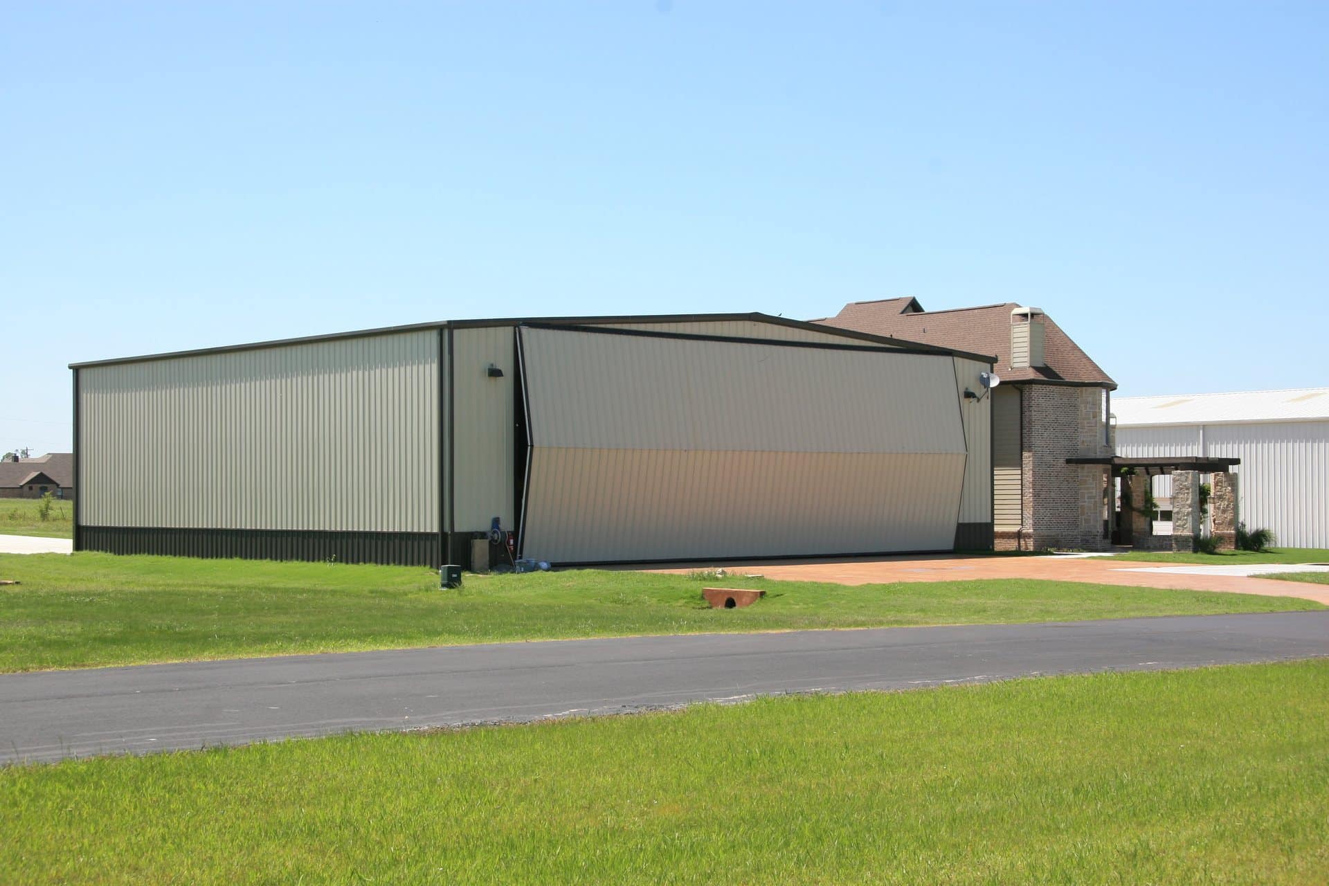 aircraft hangar hydraulic bifold door open attached residence sage metal