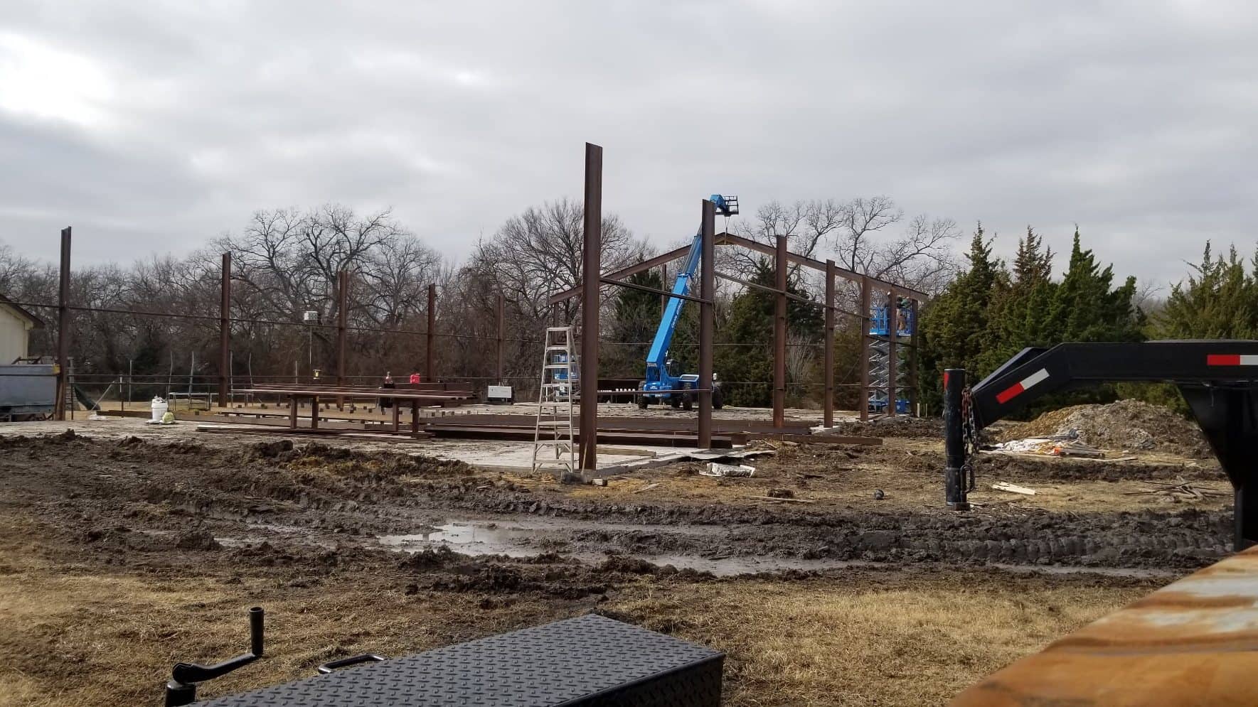 steel columns erected on slab overcast day with boom lift and crew