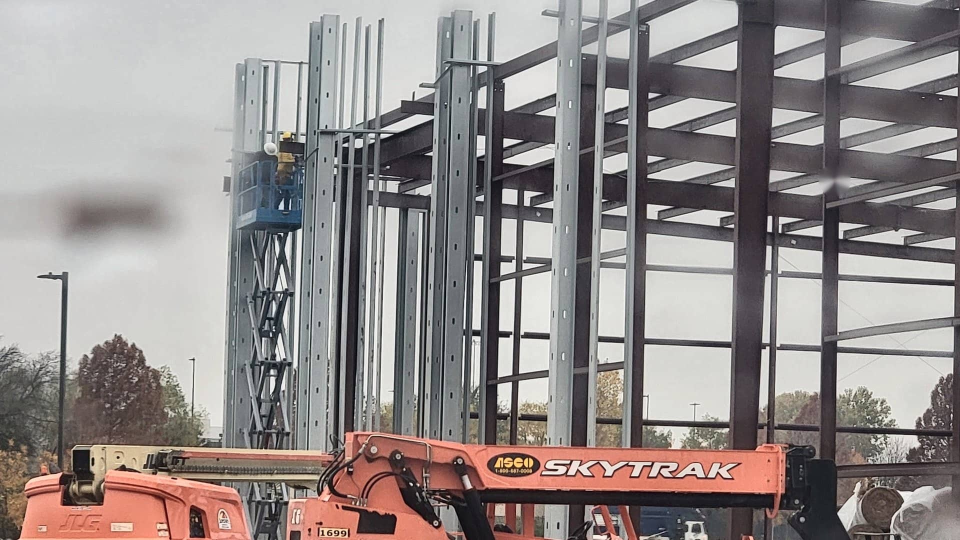 red iron frame and girts with telehandler and boom lift